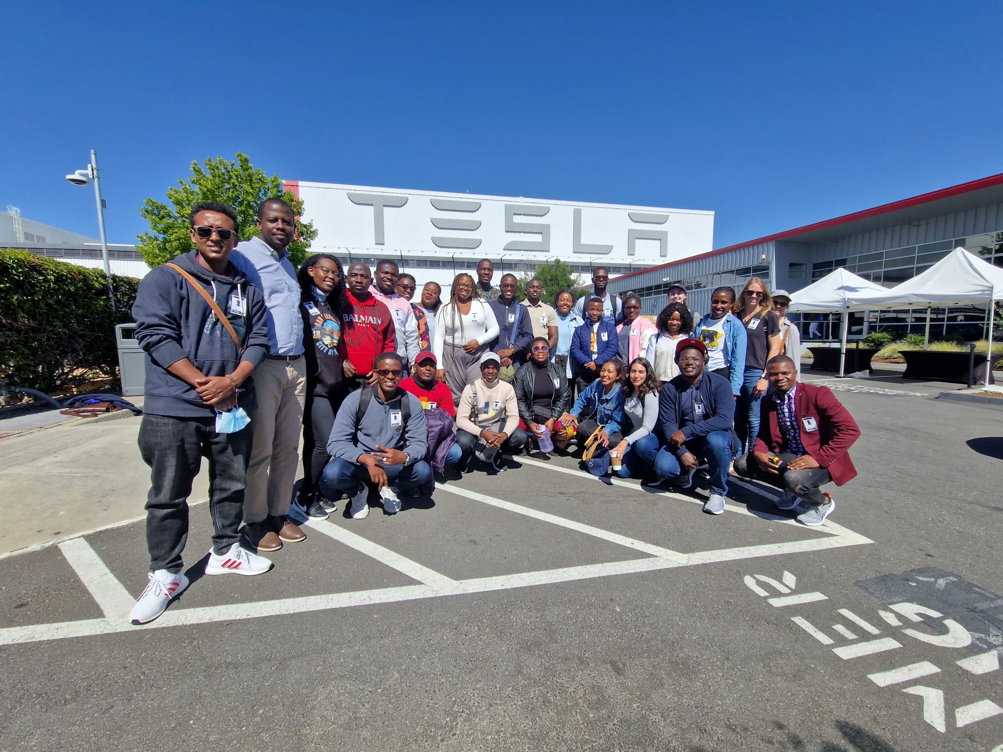 The Fellows smile for a group photo outside the Tesla Fremont Factory.