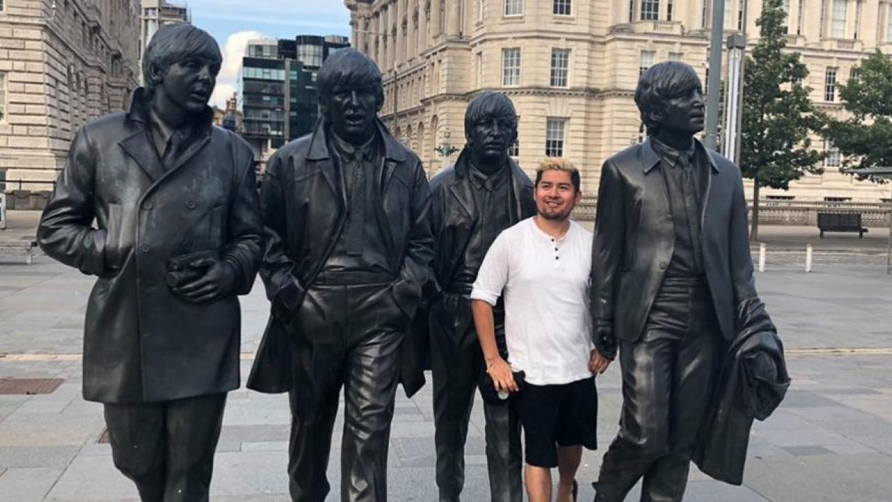 The 5th Beatle: Gonzales stands among four statues commemorating the members of The Beatles on a London street. (Courtesy Adrian Gonzales)