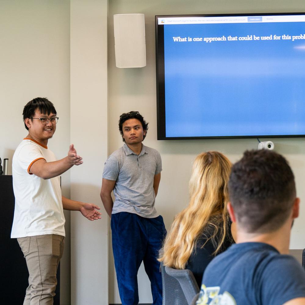 Two students present to a class in front of a screen during UC Davis Summer Session