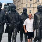 The 5th Beatle: Gonzales stands among four statues commemorating the members of The Beatles on a London street. (Courtesy Adrian Gonzales)